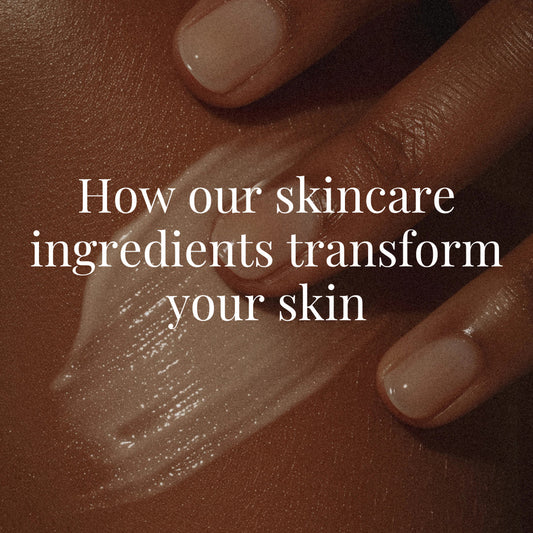 A medium brown hand spreads a luminous cream across rich brown skin in a soft, ambient light. The skin appears healthy and moisturized. White serif text overlays: “How our skincare ingredients transform your skin.”